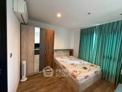 Cozy bedroom with wooden flooring, modern wardrobe, and air conditioning.