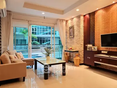 Spacious modern living room with elegant decor and large windows overlooking a balcony.