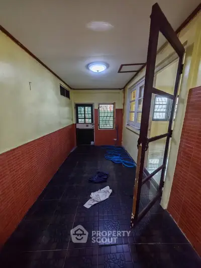 Narrow interior space with tiled floor and glass door, ideal for storage or utility use.