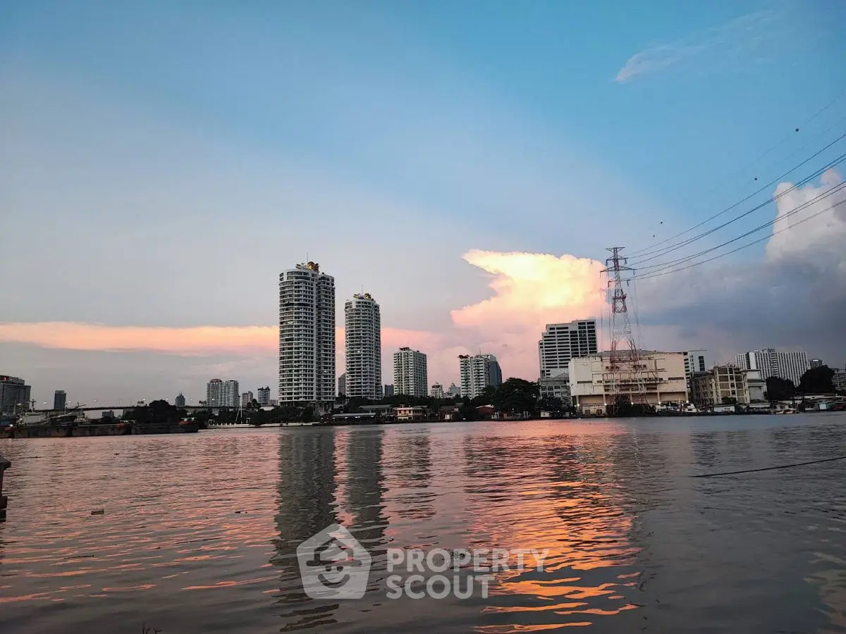 Stunning riverside view with modern high-rise buildings at sunset.