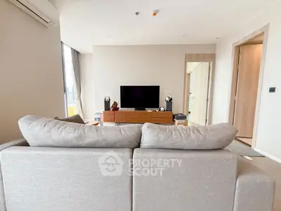 Modern living room with stylish decor and city view, featuring a comfortable sofa and entertainment center.