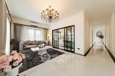Elegant living room with chandelier, plush sofa, and open layout in luxury home.