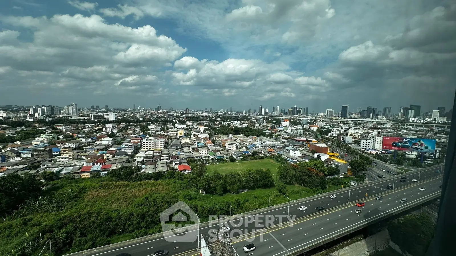 Stunning cityscape view from high-rise building with expansive skyline and lush greenery.