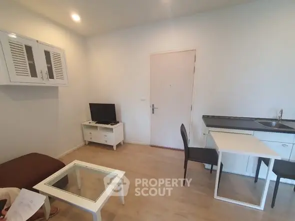 Cozy living room with modern furniture and compact kitchen area.