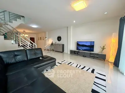 Spacious modern living room with sleek black leather sofa and stylish decor