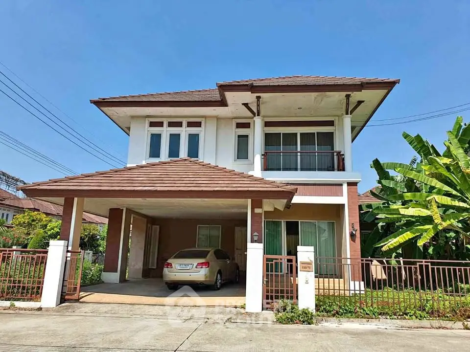 Charming two-story house with carport and lush garden in suburban neighborhood.