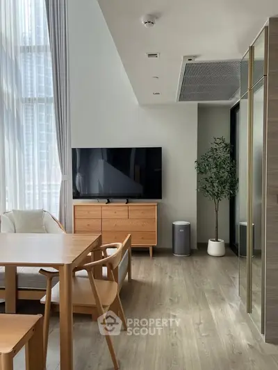 Modern living room with high ceilings, large windows, and minimalist furniture in a stylish apartment.