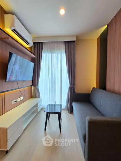 Modern living room with sleek furniture and large window for natural light.