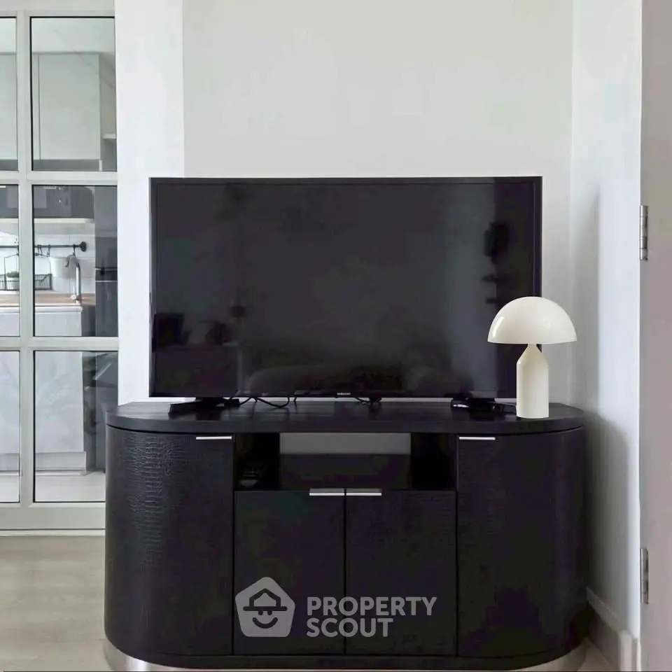 Modern living room with sleek TV stand and stylish lamp, perfect for contemporary home decor.