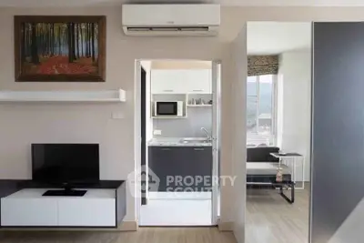Modern apartment interior with sleek kitchen and cozy living area, featuring stylish decor and efficient layout.