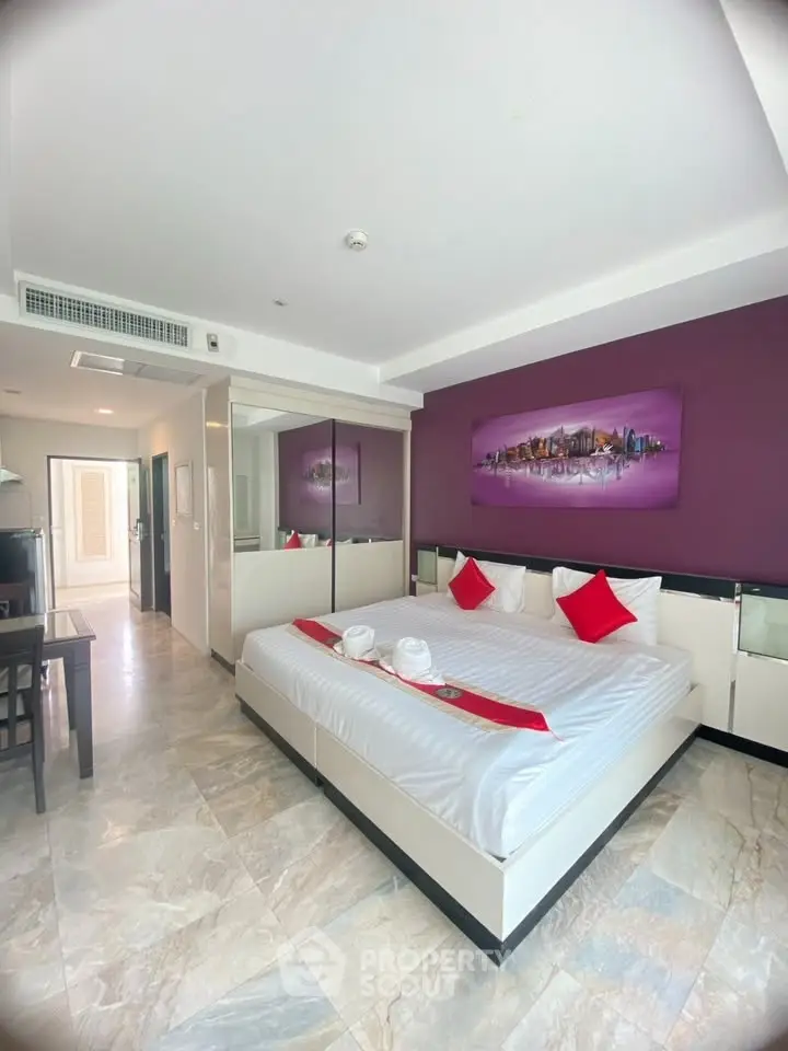 Spacious modern bedroom with stylish decor and large bed in a well-lit apartment.