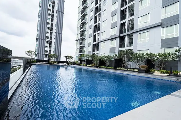 Modern apartment building with sleek design and poolside view, perfect for luxury living.