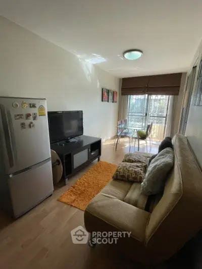 Cozy living room with natural light, modern decor, and a compact dining area.