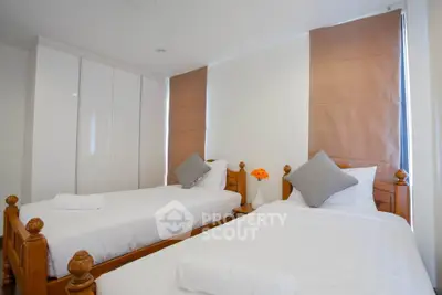 Spacious twin bedroom with modern decor and ample natural light