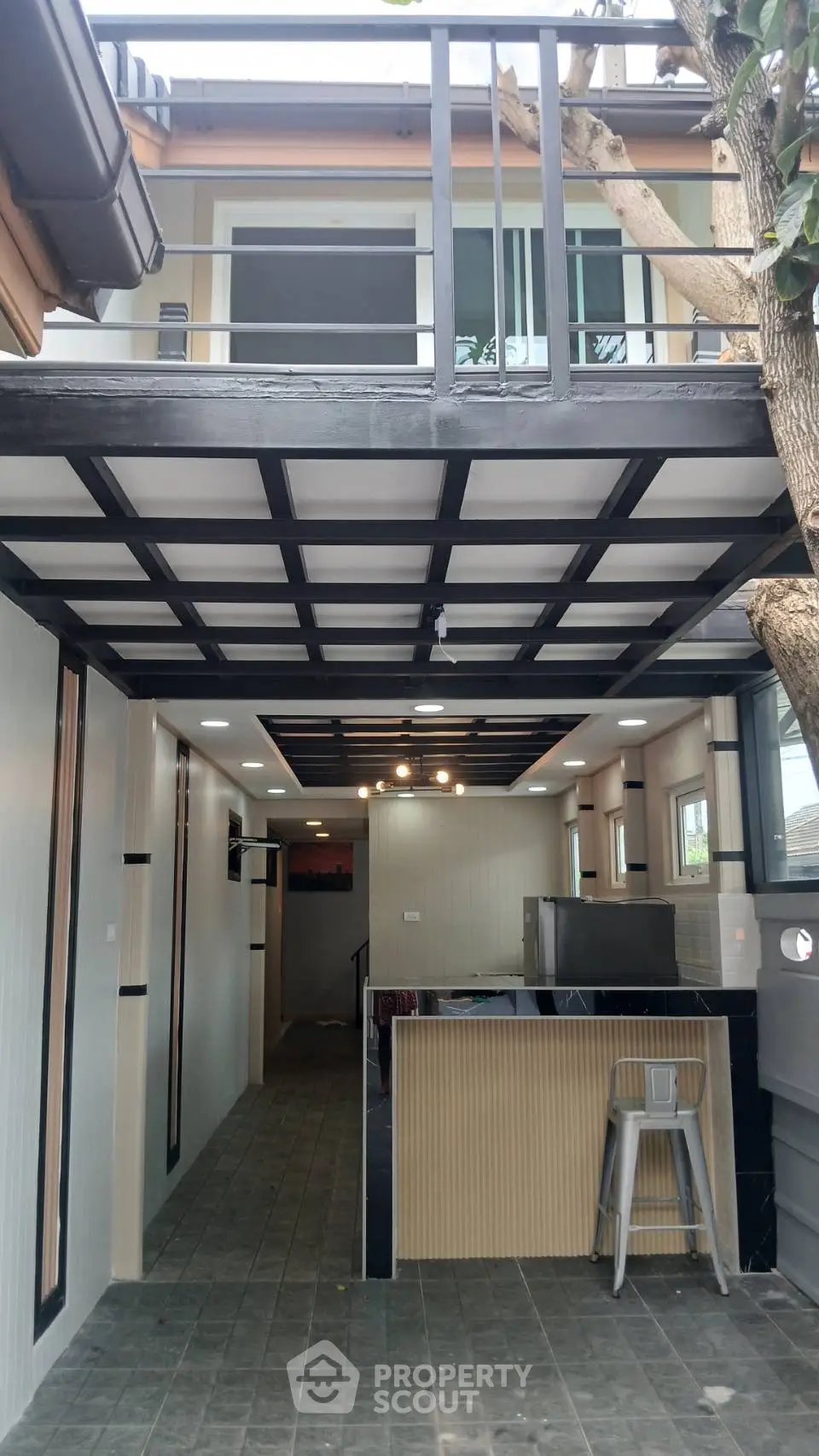 Modern two-story home with open-air ground floor and sleek balcony design.