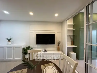 Modern living room with elegant decor and built-in TV unit, featuring stylish dining area and ambient lighting.