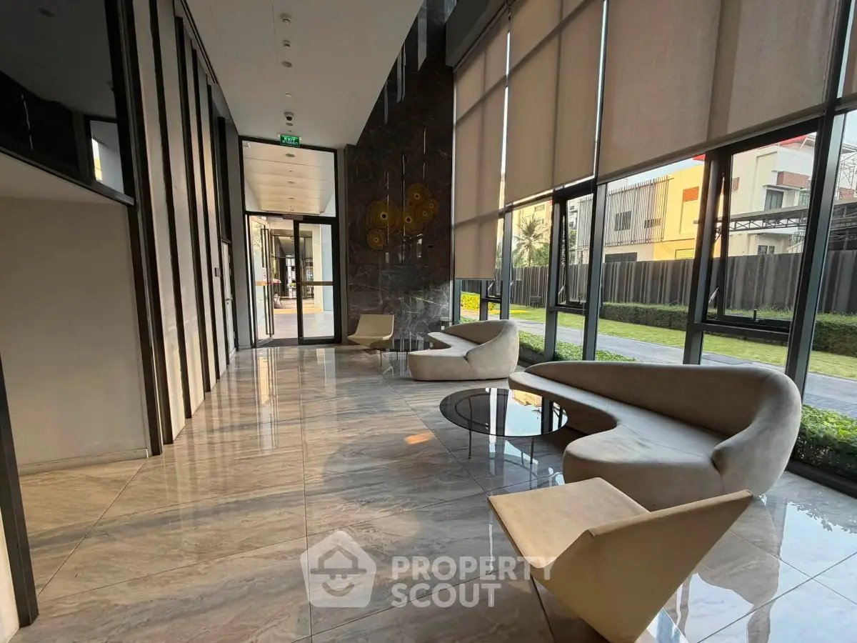 Luxurious modern lobby with sleek furniture and large windows offering garden views.