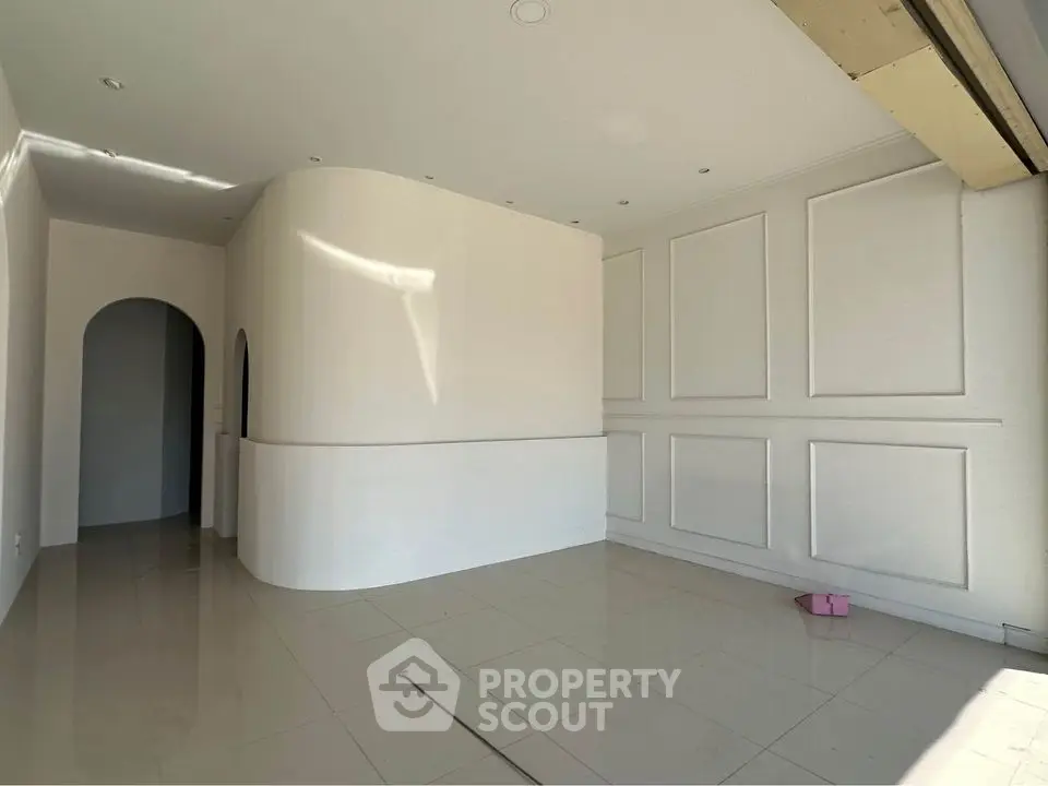 Spacious modern interior with elegant curved wall and glossy tiled floor