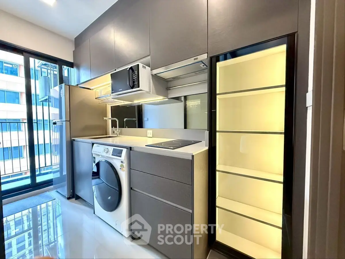 Modern kitchen with sleek appliances and ample storage in a stylish apartment.