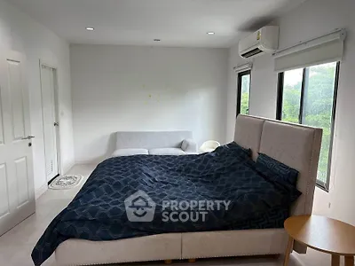 Spacious bedroom with large windows and modern furnishings