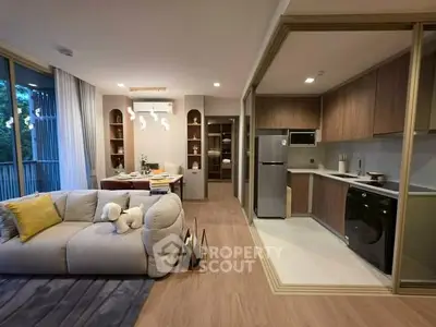 Modern open-plan living room and kitchen with stylish decor and natural light.