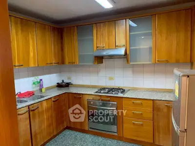 Spacious kitchen with wooden cabinets and modern appliances in a cozy home.