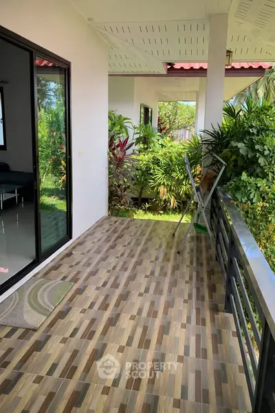 Charming balcony with lush garden view and modern tiled flooring