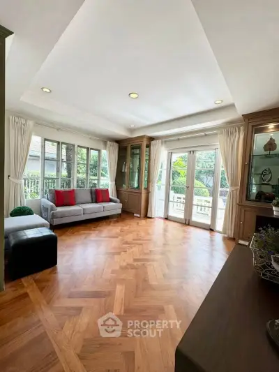 Spacious living room with elegant parquet flooring and garden view