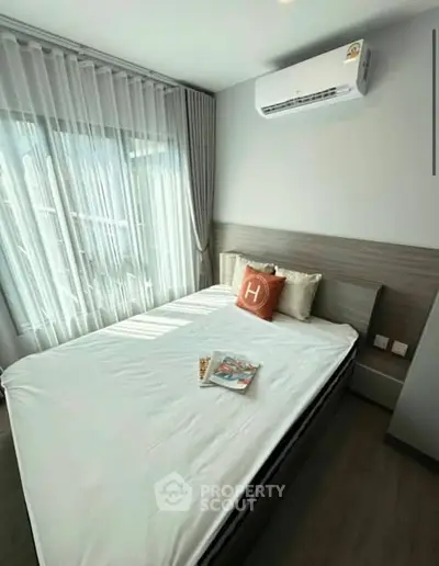Modern bedroom with air conditioning and natural light, featuring stylish decor and cozy ambiance.