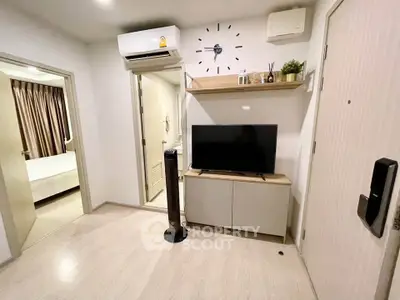Modern living room with sleek TV setup and air conditioning, adjacent to a cozy bedroom.