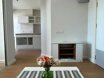 Modern apartment interior with stylish kitchen and cozy living area, featuring elegant decor and wooden flooring.