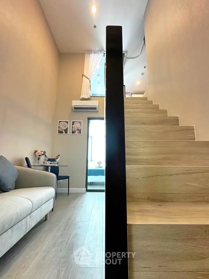 Modern duplex interior with wooden staircase and cozy living area