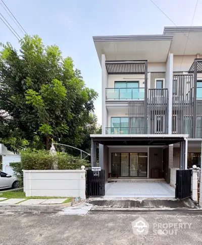 Modern townhouse exterior with sleek design and spacious driveway in a serene neighborhood.