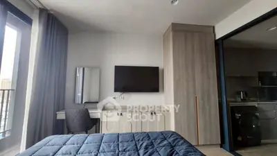 Modern bedroom with TV, wardrobe, and balcony view