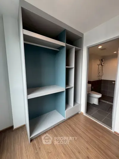 Spacious walk-in closet with modern bathroom view in contemporary apartment