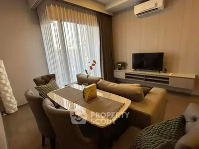 Modern living room with elegant dining area and cozy seating, featuring a wall-mounted TV and air conditioning.