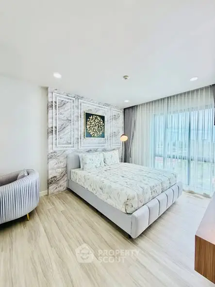 Elegant bedroom with modern decor and large window offering natural light