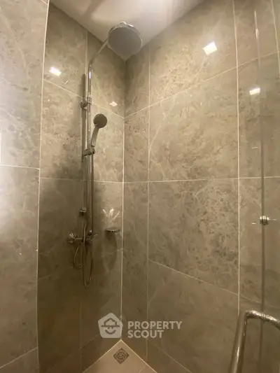 Luxurious marble-tiled shower with modern fixtures in elegant bathroom