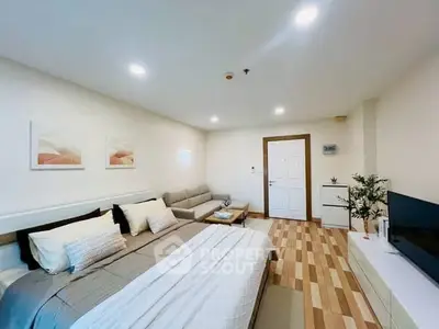 Spacious modern bedroom with cozy seating area and stylish decor