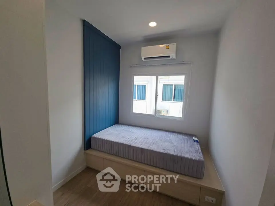 Cozy bedroom with modern design and natural light, featuring a built-in bed and air conditioning.