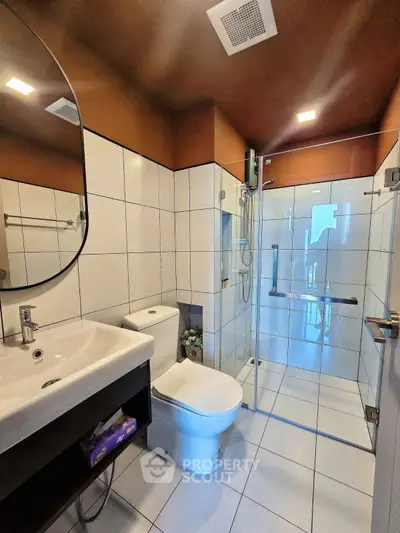 Modern bathroom with sleek design, glass shower, and stylish fixtures.