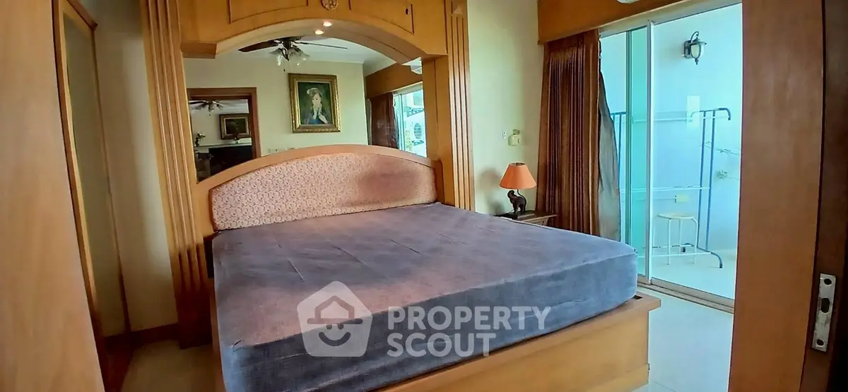 Cozy bedroom with large bed and balcony access in a stylish apartment.