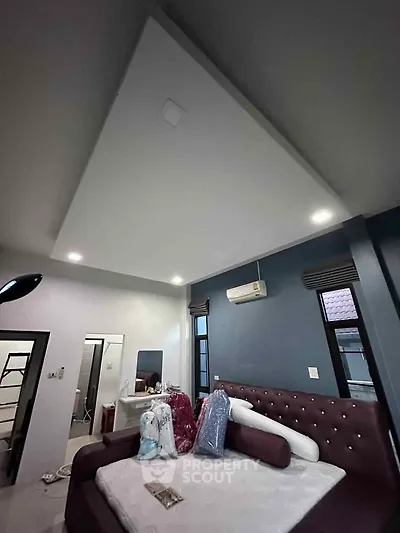 Spacious bedroom with modern ceiling design and plush furnishings