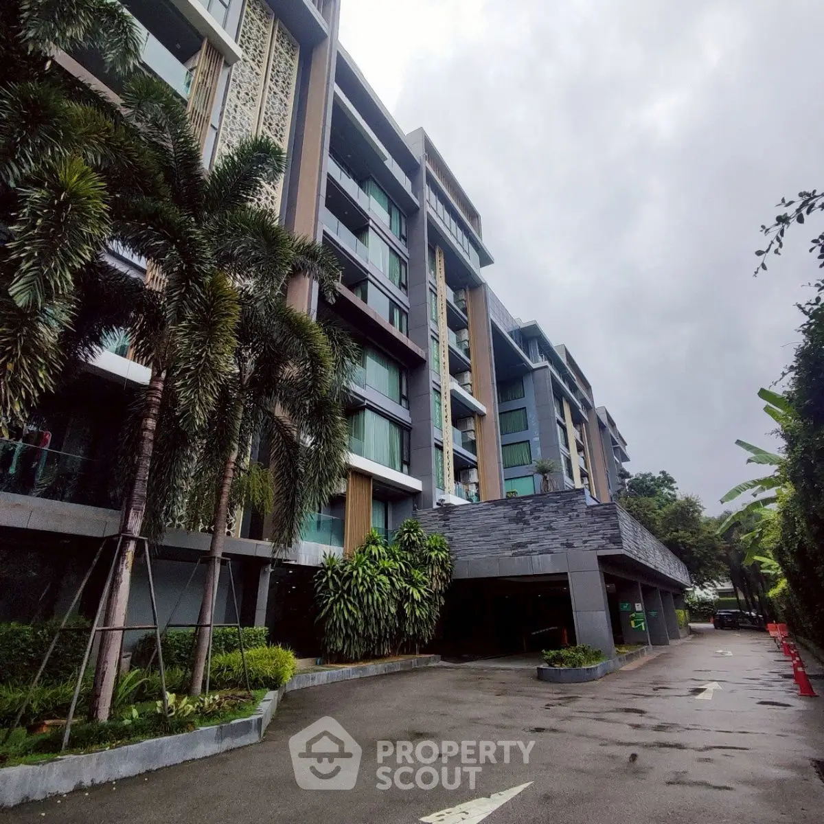 Modern apartment building with lush greenery and spacious driveway