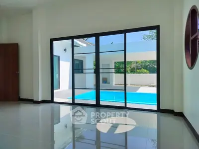 Spacious living room with pool view and large glass doors in modern home