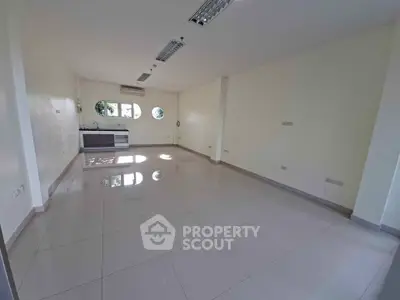 Spacious unfurnished room with tiled flooring and modern lighting, ideal for customization.