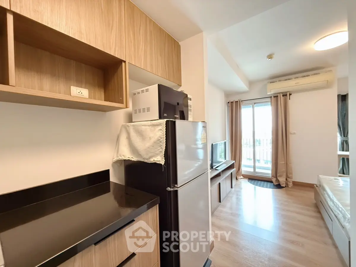 Modern studio apartment with open kitchen and balcony view