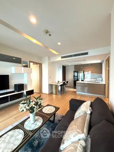 Spacious modern living room with open kitchen, stylish decor, and natural light, perfect for urban living.