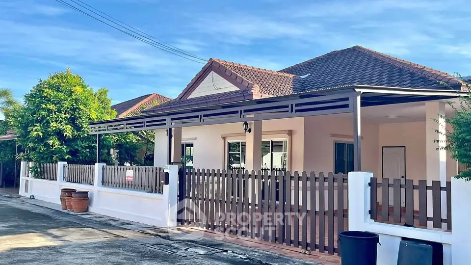 Charming single-story house with tiled roof and fenced yard in a serene neighborhood.