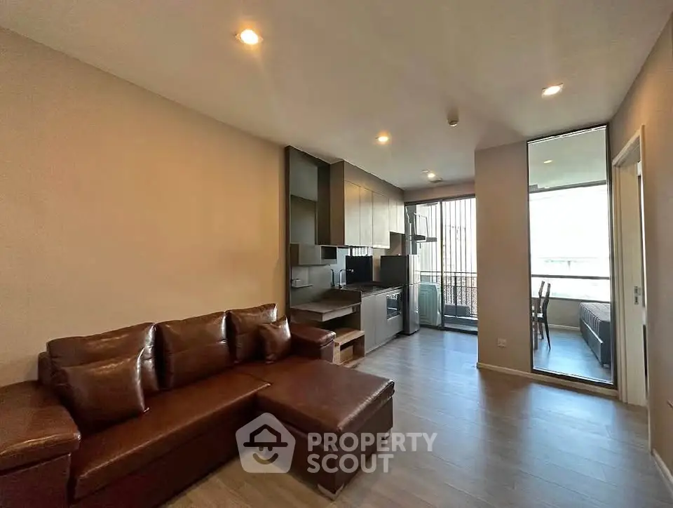 Modern living room with open kitchen and balcony in a stylish apartment.